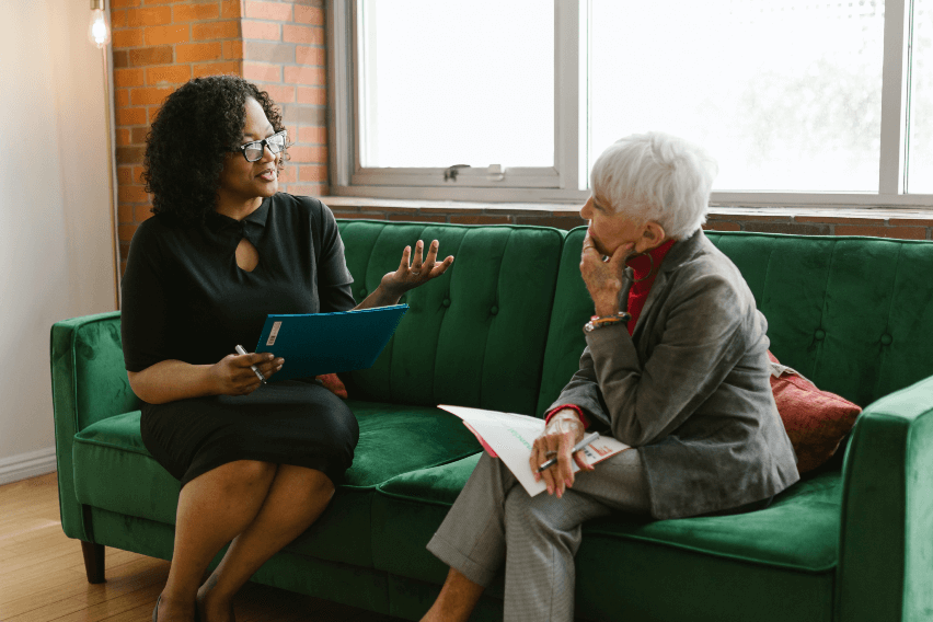 Two professional women sitting on a couch talking